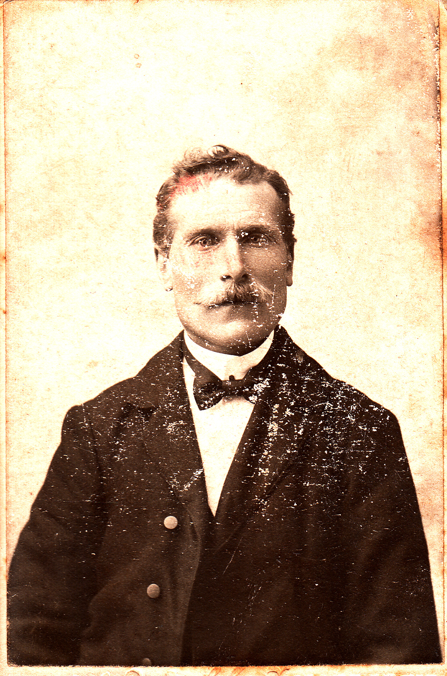 an old pograph of a man in a black suit and bow tie