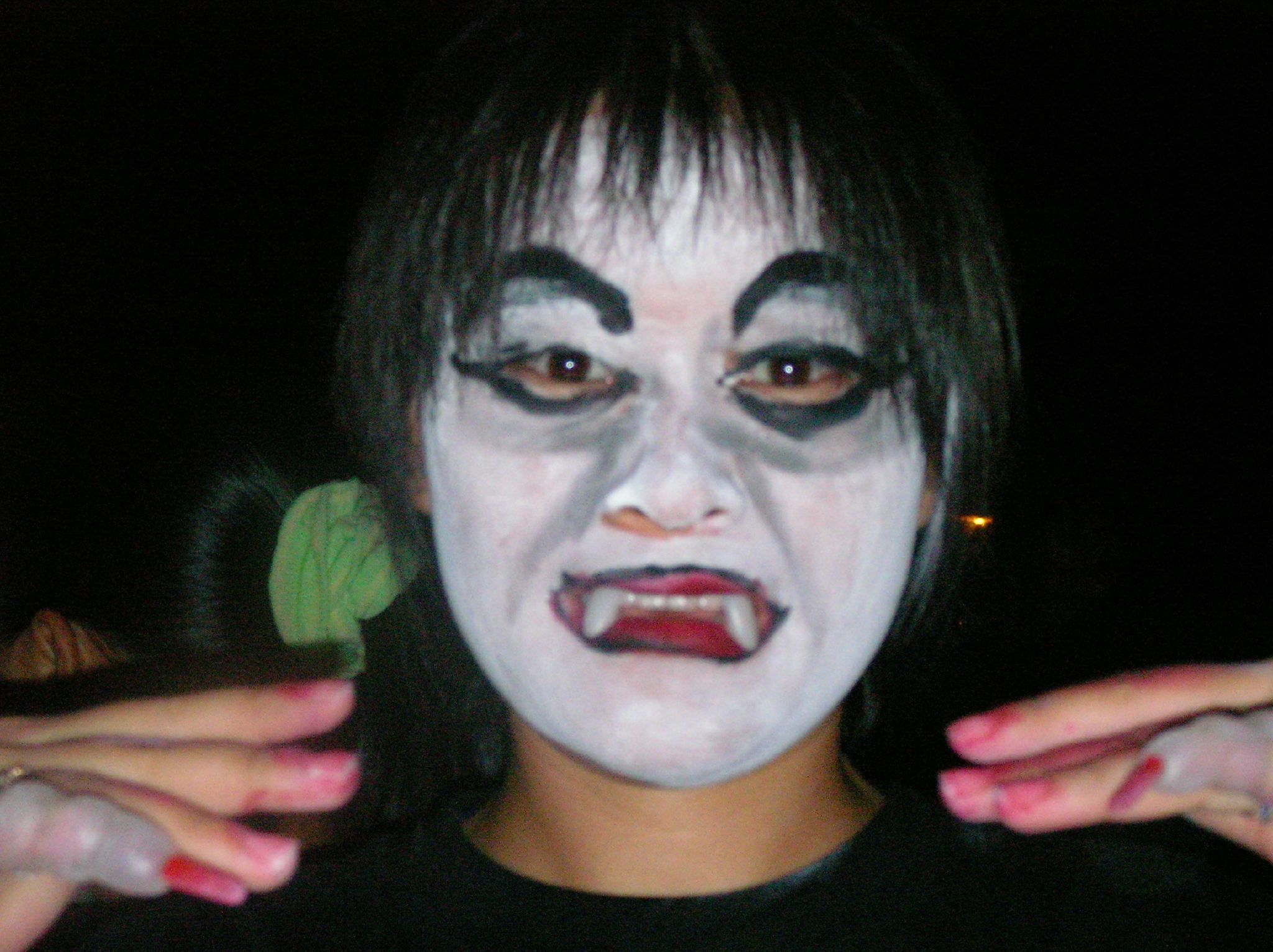 an adult wearing a face paint holding a phone