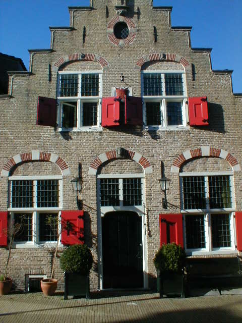 there is a brick building with red shutters