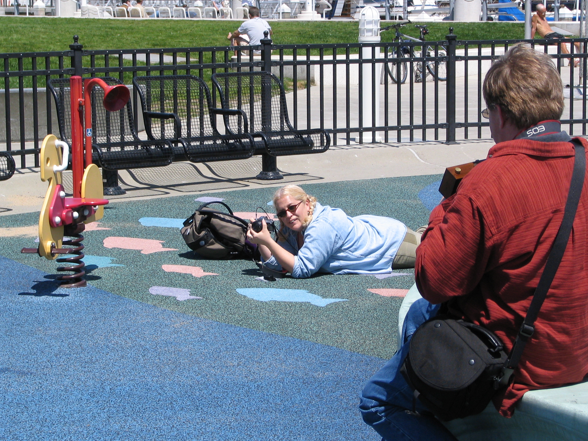 a woman taking a po with her camera while laying on the ground