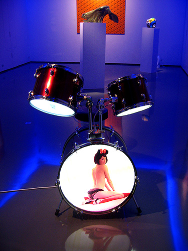 the image of a woman is displayed in front of drum kits