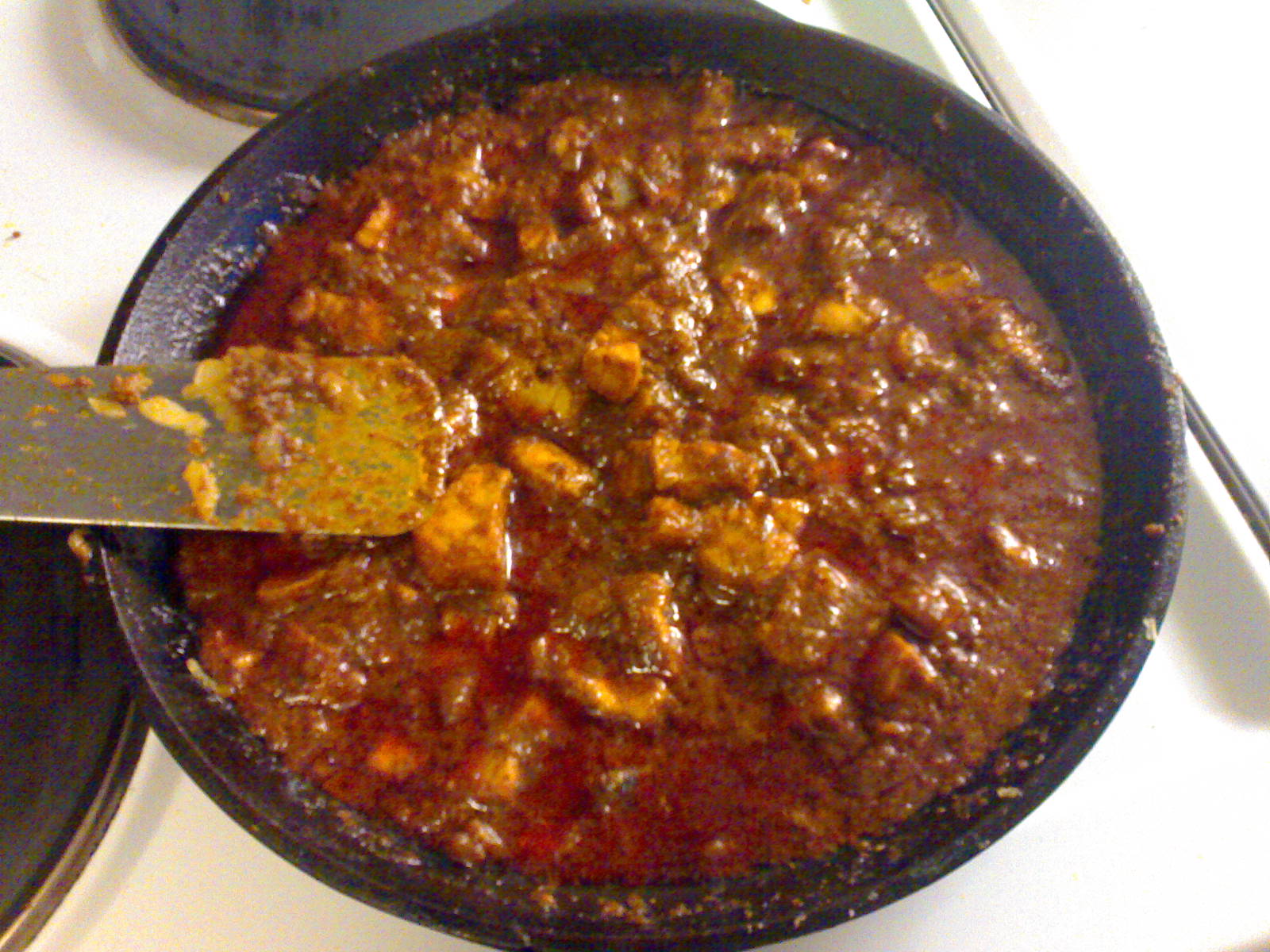 a pot full of chili sitting on the stove