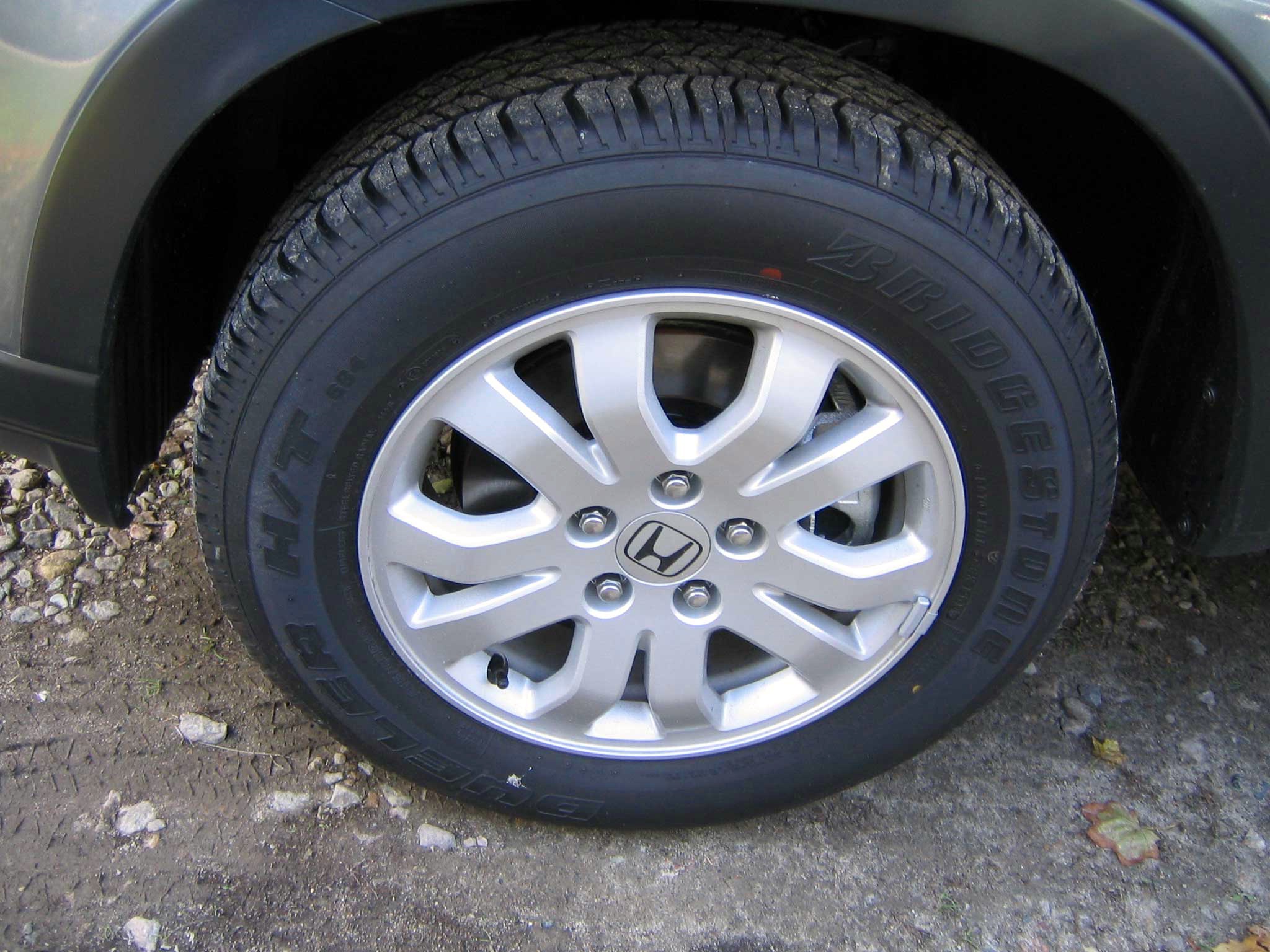 the front wheel of a car on gravel surface
