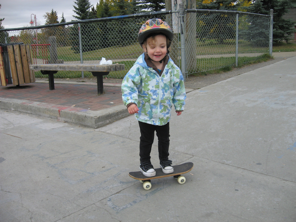 a boy on a skateboard near a bench