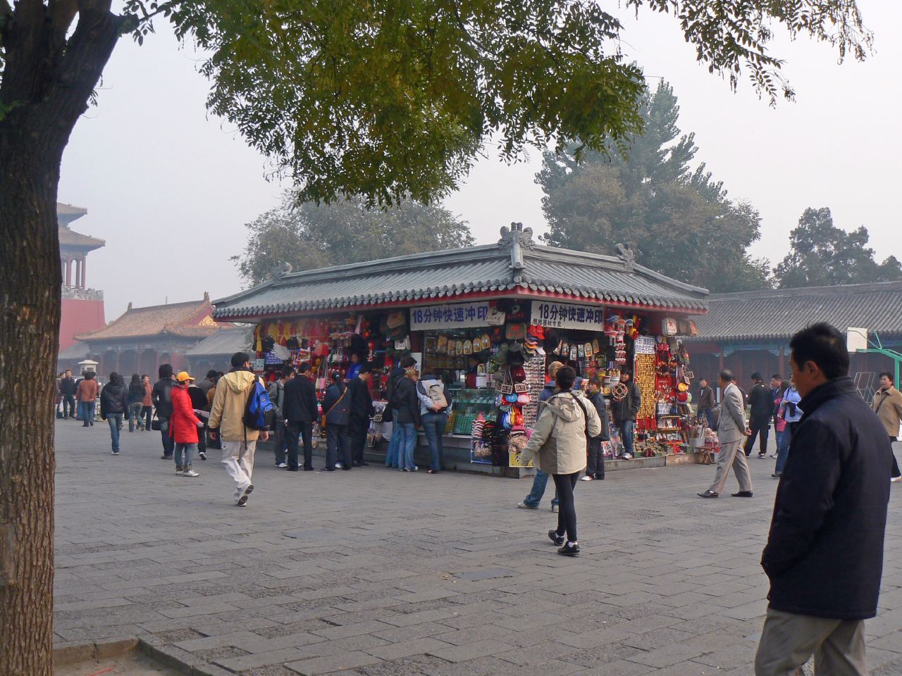 a group of people walking on a street near buildings