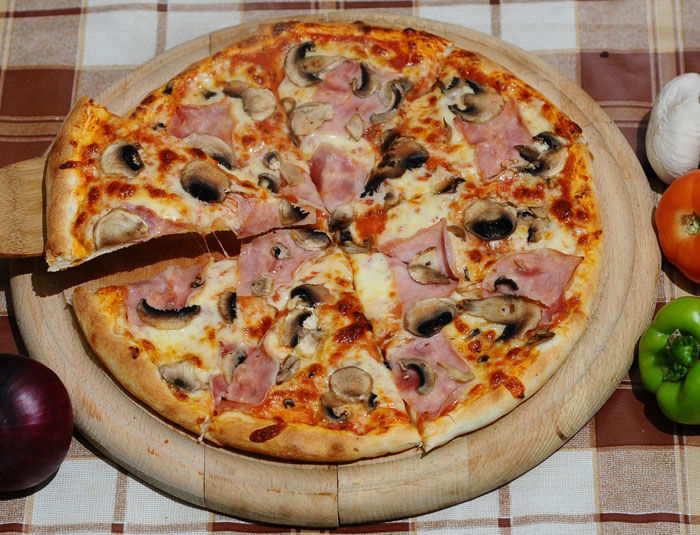 a homemade pizza with meat and cheese on a table