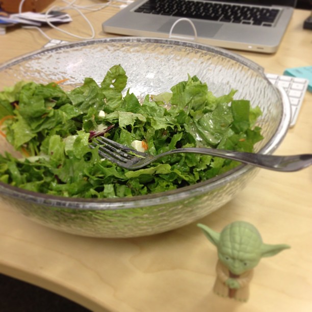 there is a salad in the bowl with a fork in it