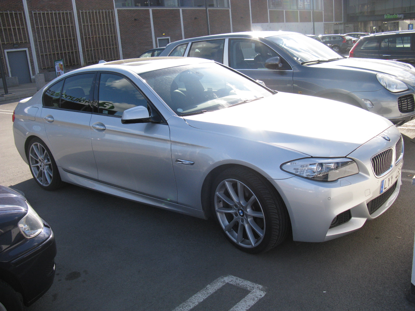 a silver car parked in the parking lot in front of other cars