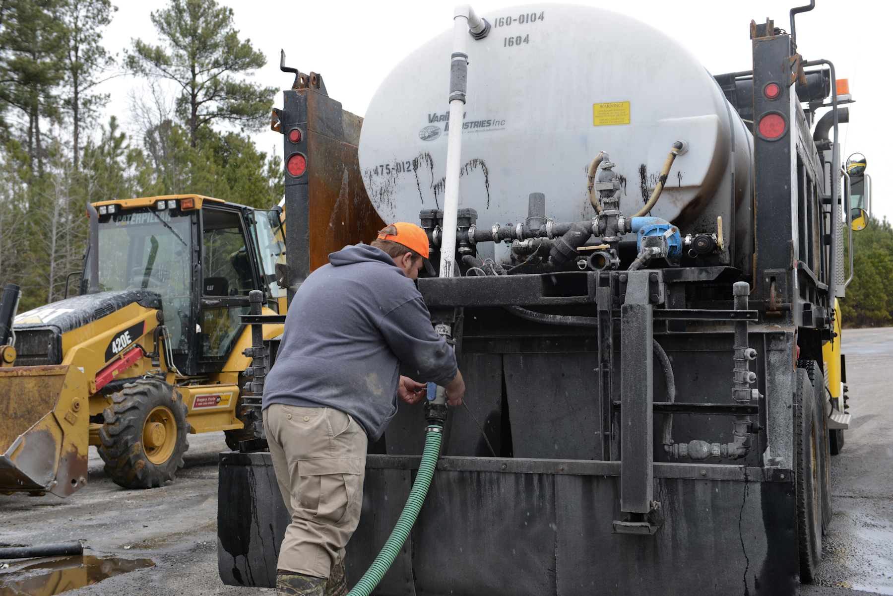 a man is pouring concrete into a large machine