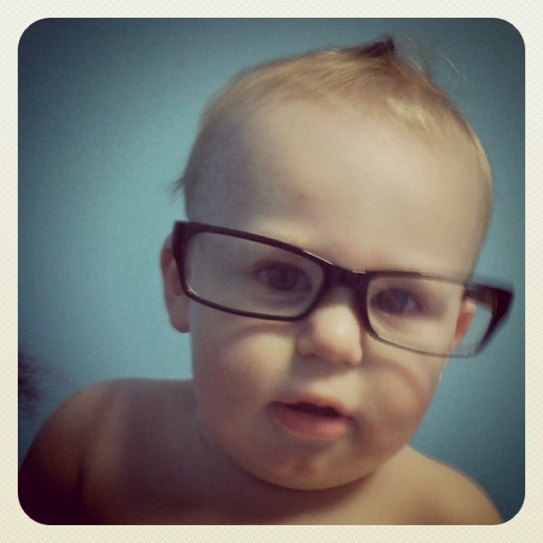a close up of a baby wearing glasses