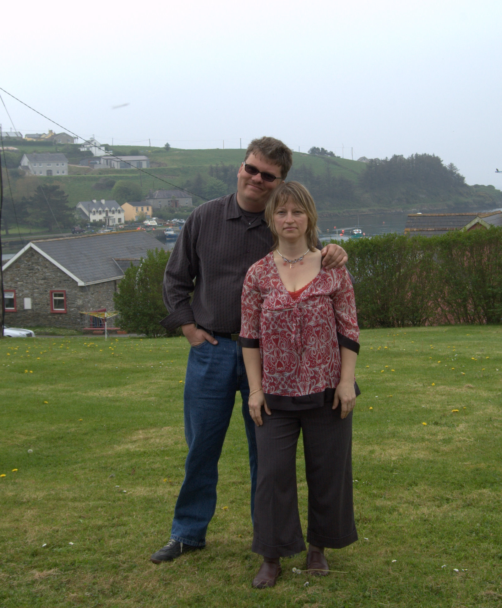 a couple of people that are posing in the grass