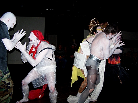 several people in various costumes are dancing in the dark