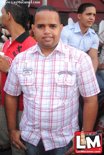 a man in a checkered shirt is smiling at the camera
