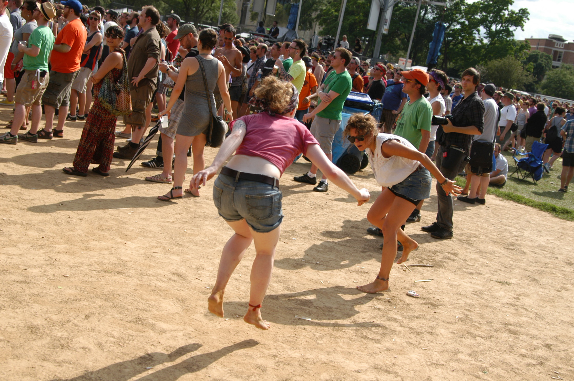 women are dancing on the side of a large group