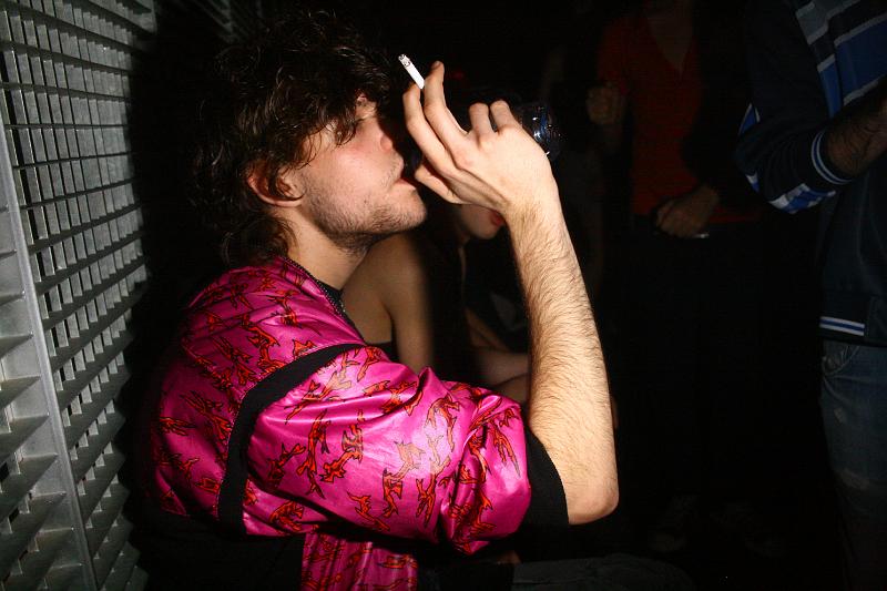 a young man smoking in a dark room