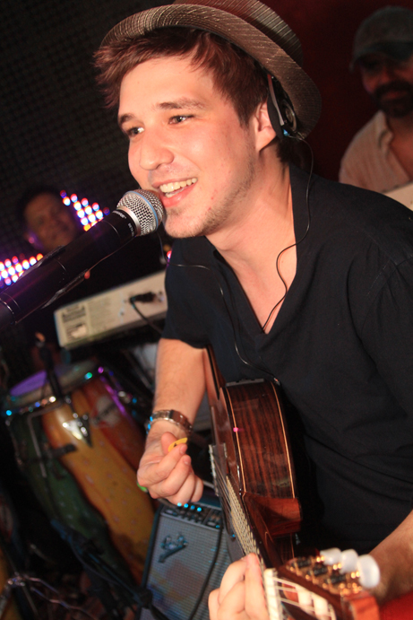 a man that is playing a guitar near a microphone