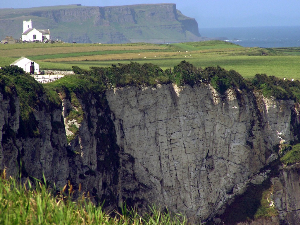 the cliff and house is located on a rocky island in front of the water