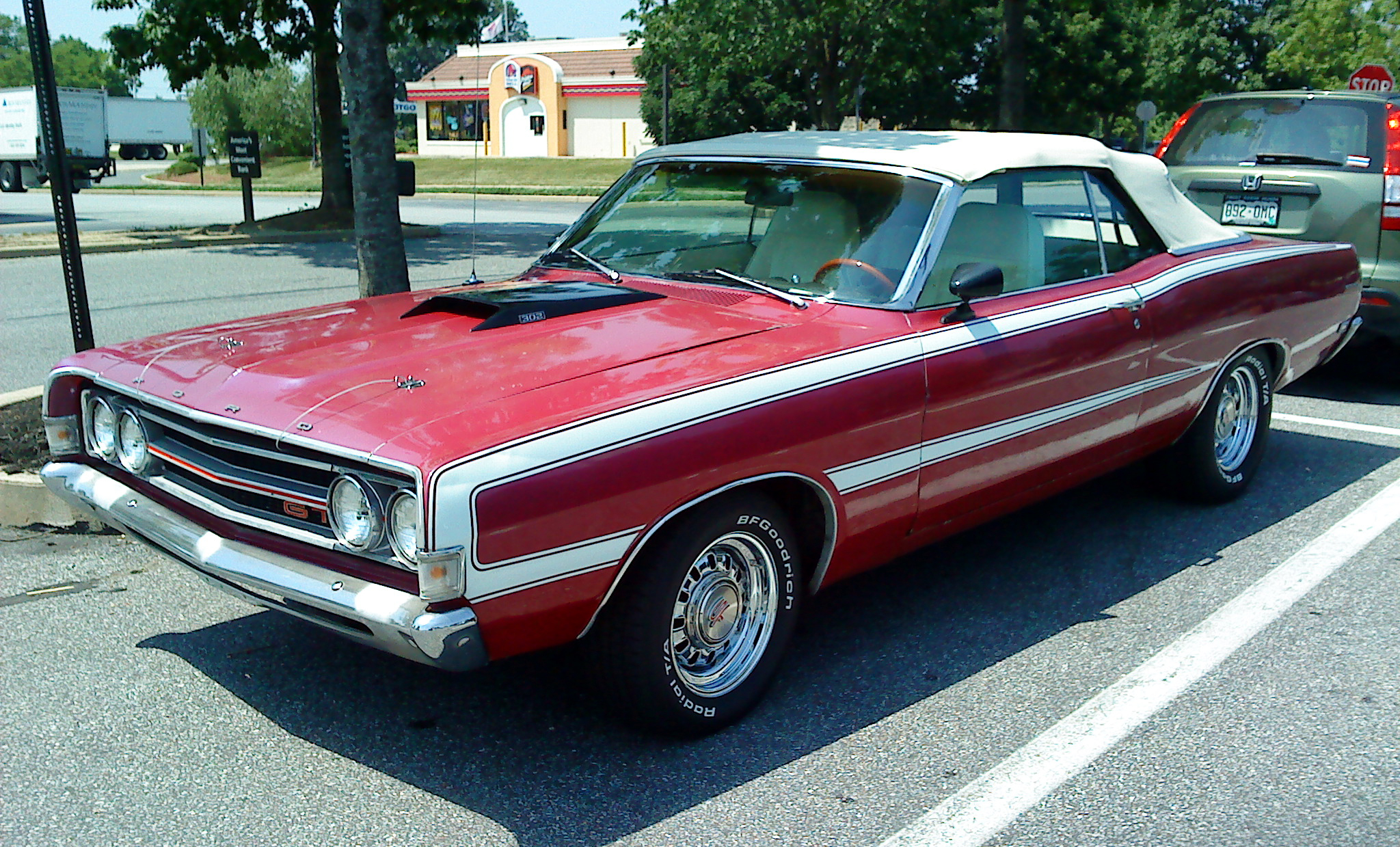 a red car is parked in a parking lot