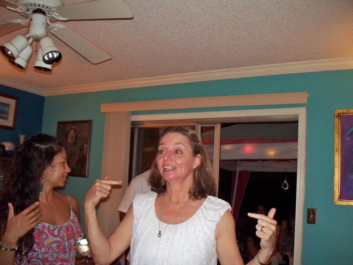 an older woman showing two thumbs while she stands next to another woman