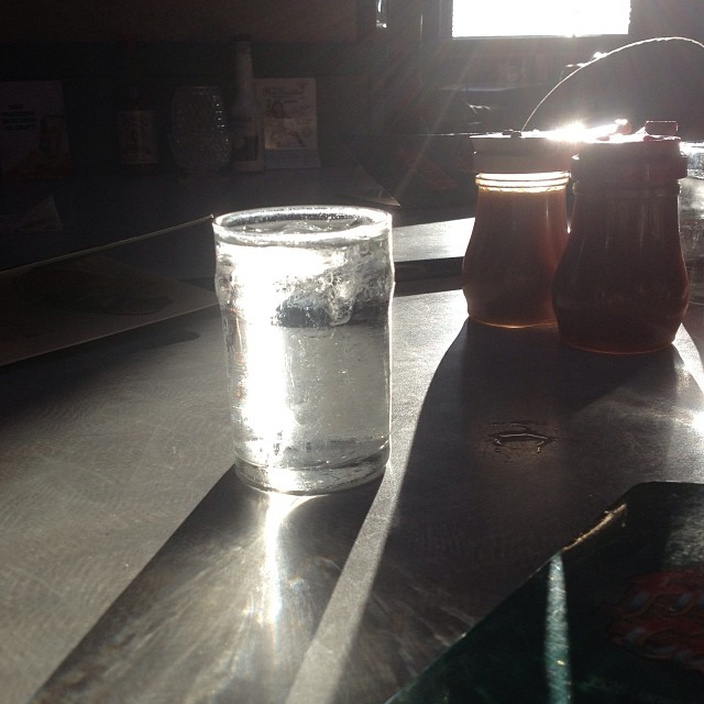 three glasses of water are on the table near a canister