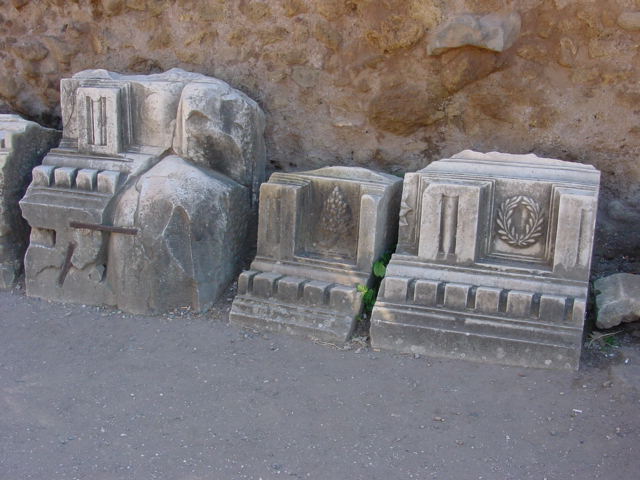 stone carvings of heads, feet and arms are near the rocks