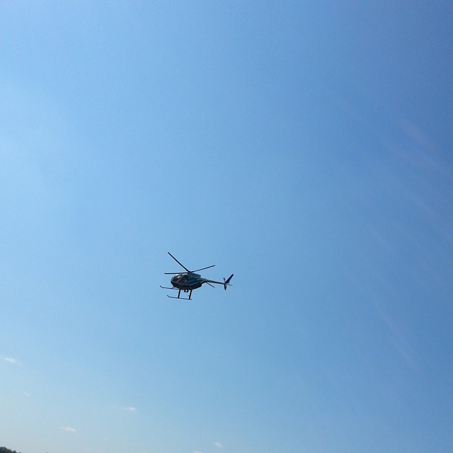 a helicopter flying low to the ground over the beach