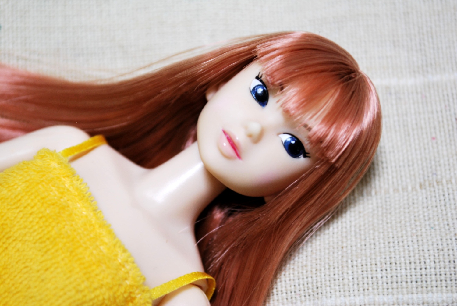 a doll with blue eyes lies on a blanket