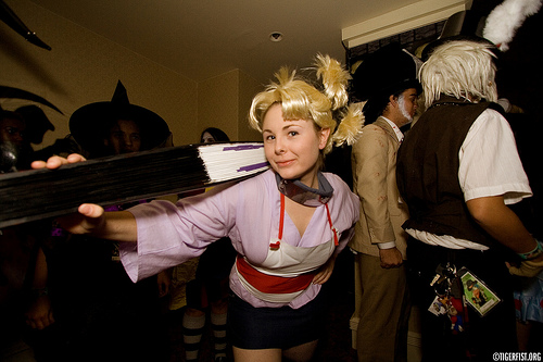 two females are wearing costumes and one is holding an object