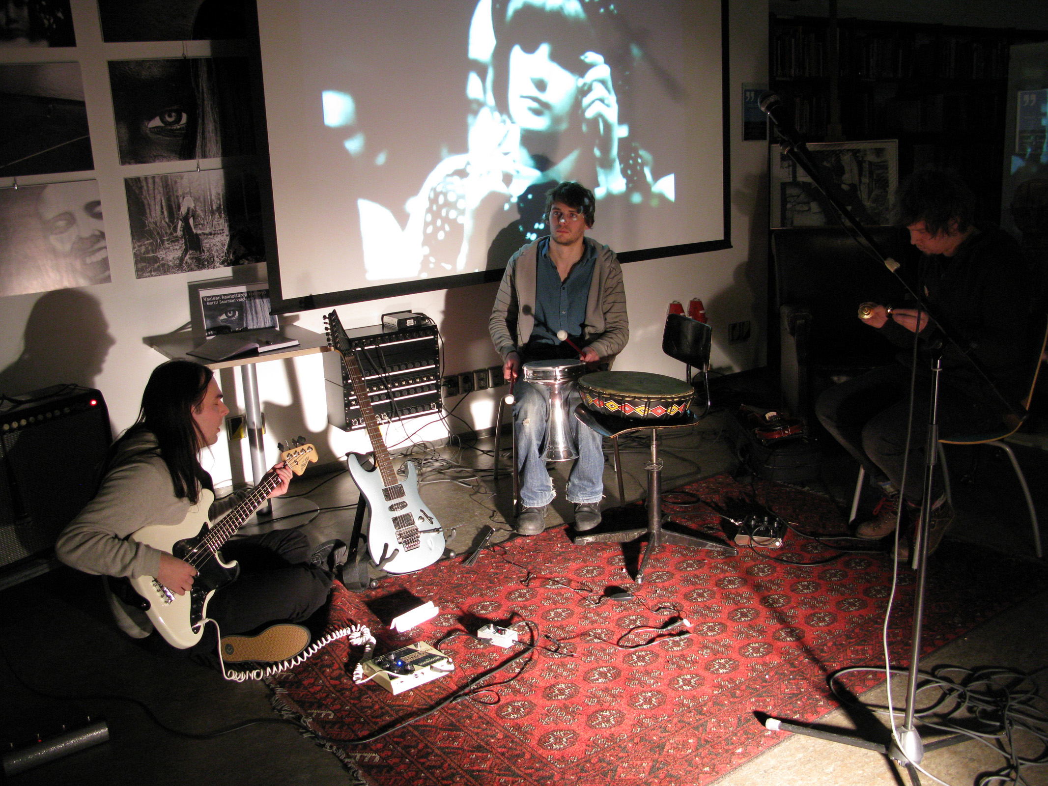 three people in an open studio playing music with their instruments