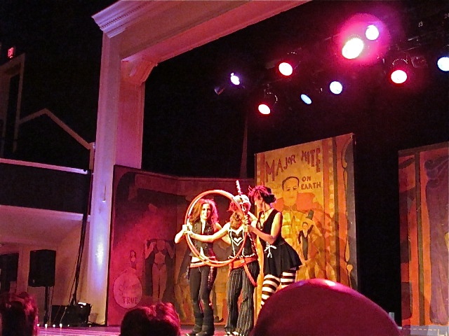 three people performing on stage at night