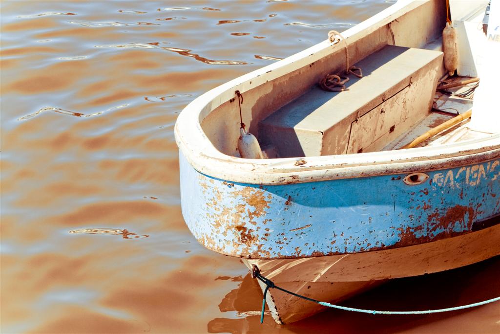 a boat sitting in the water with an old rope