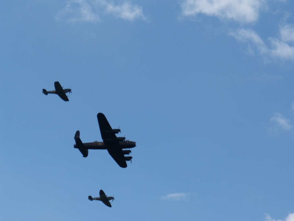 three planes flying in formation against a cloudless blue sky