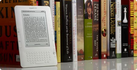 an electronic device sits near a group of books