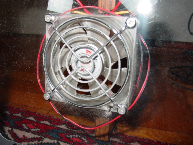 an old metal fan with red cords in front of a rug