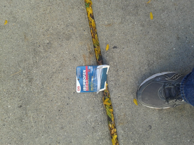 a broken toothbrush lays on a sidewalk