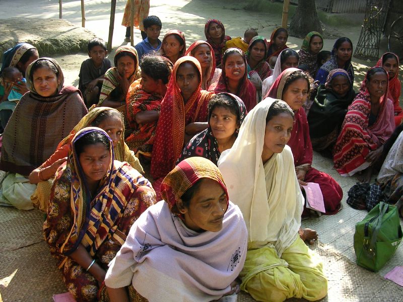 women in colorful outfits sitting on the ground