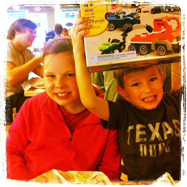 two boys with toy cars are at the restaurant