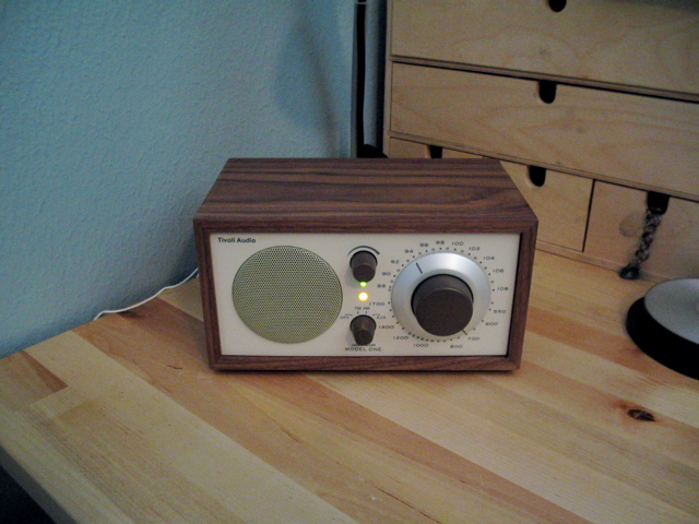 an old radio sitting on the counter next to a night stand