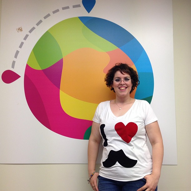 a women who is standing next to a colorful wall