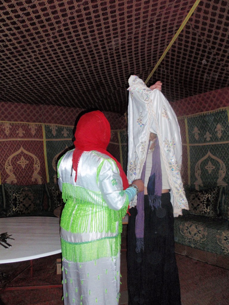 two women in brightly colored clothing stand by a table