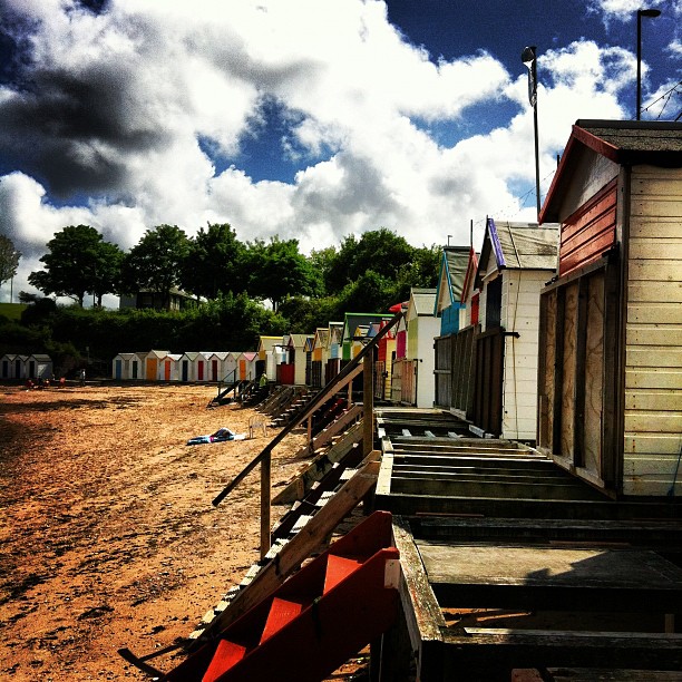 a row of beach huts sitting along side a body of water