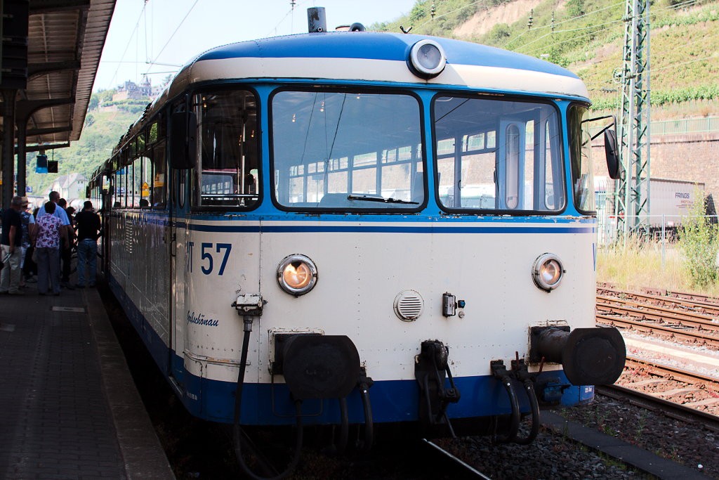 this is a train at a station with people walking along the platform