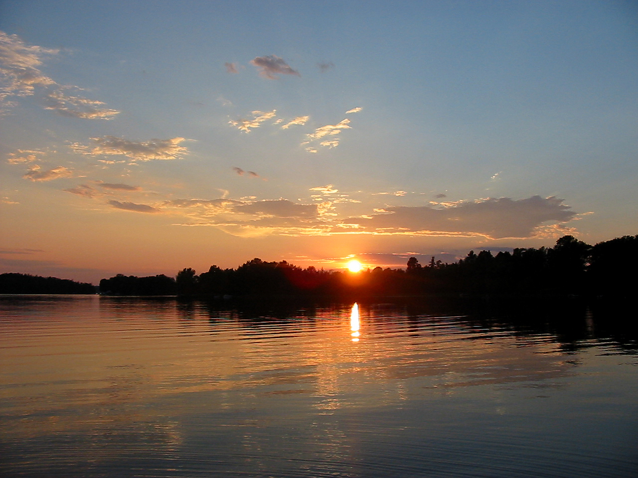 a sunset view of a river from the shore