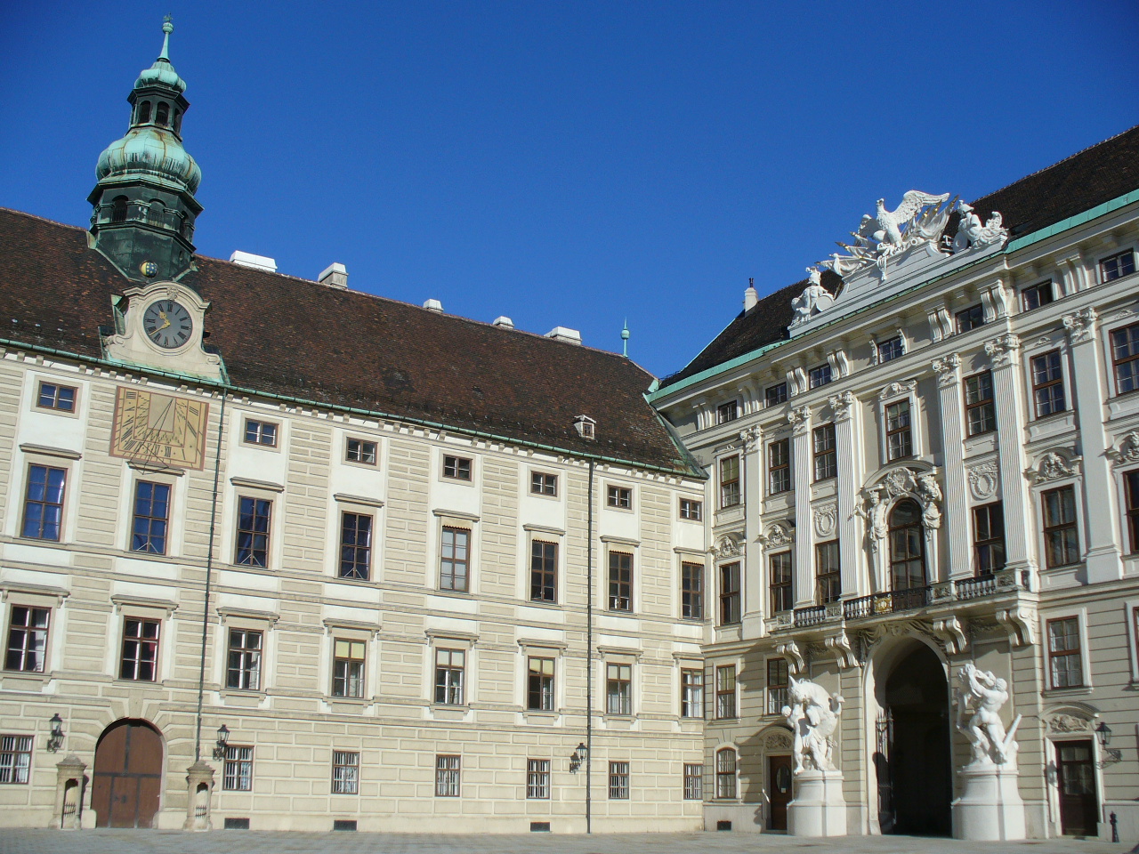 several statues stand around a building with lots of windows