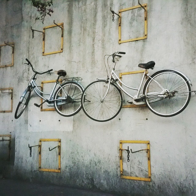 two bicycles parked against a concrete wall