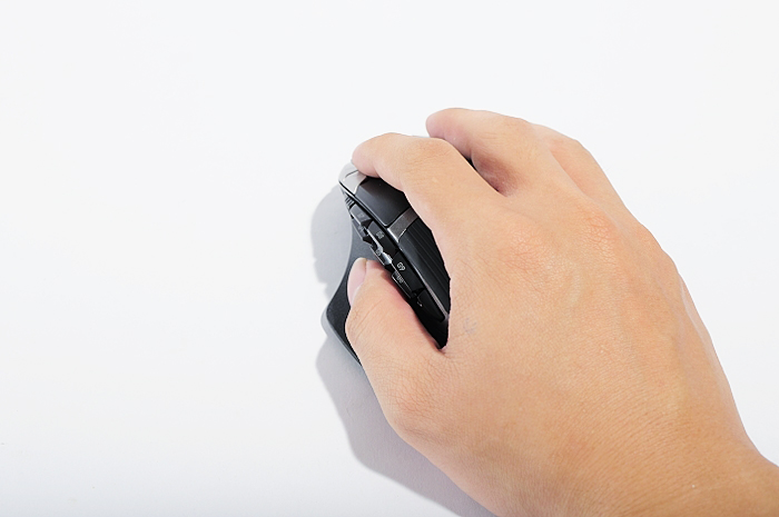 a person's hand is holding the back of their mouse