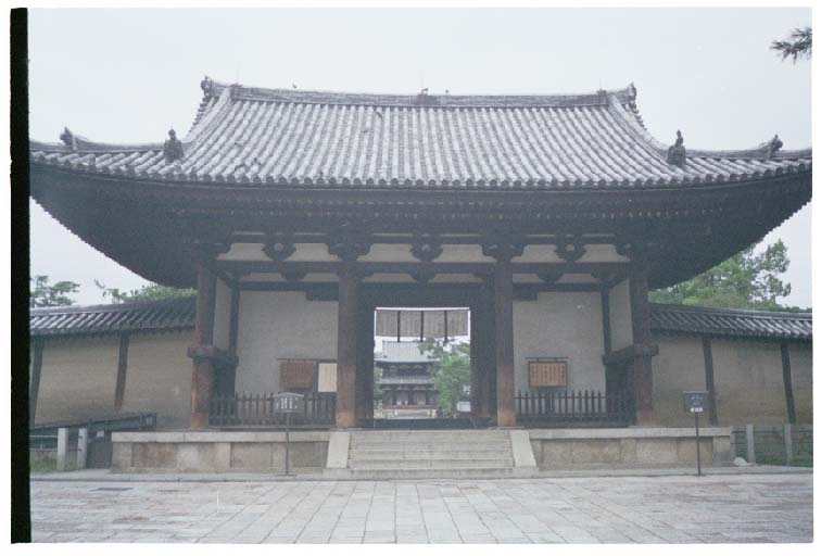 a small pagoda in front of a building with pillars