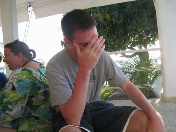 a man in a grey shirt sitting on a bench