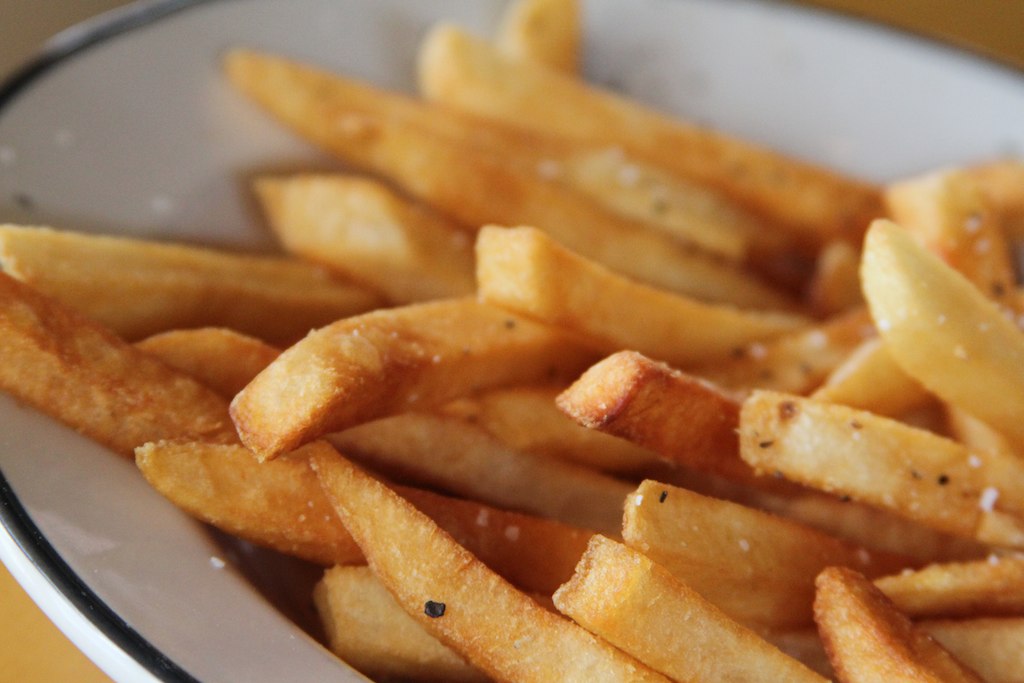 closeup view of fries in a bowl with sauce