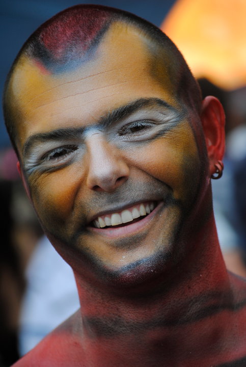 a man with painted skin and piercings on his head
